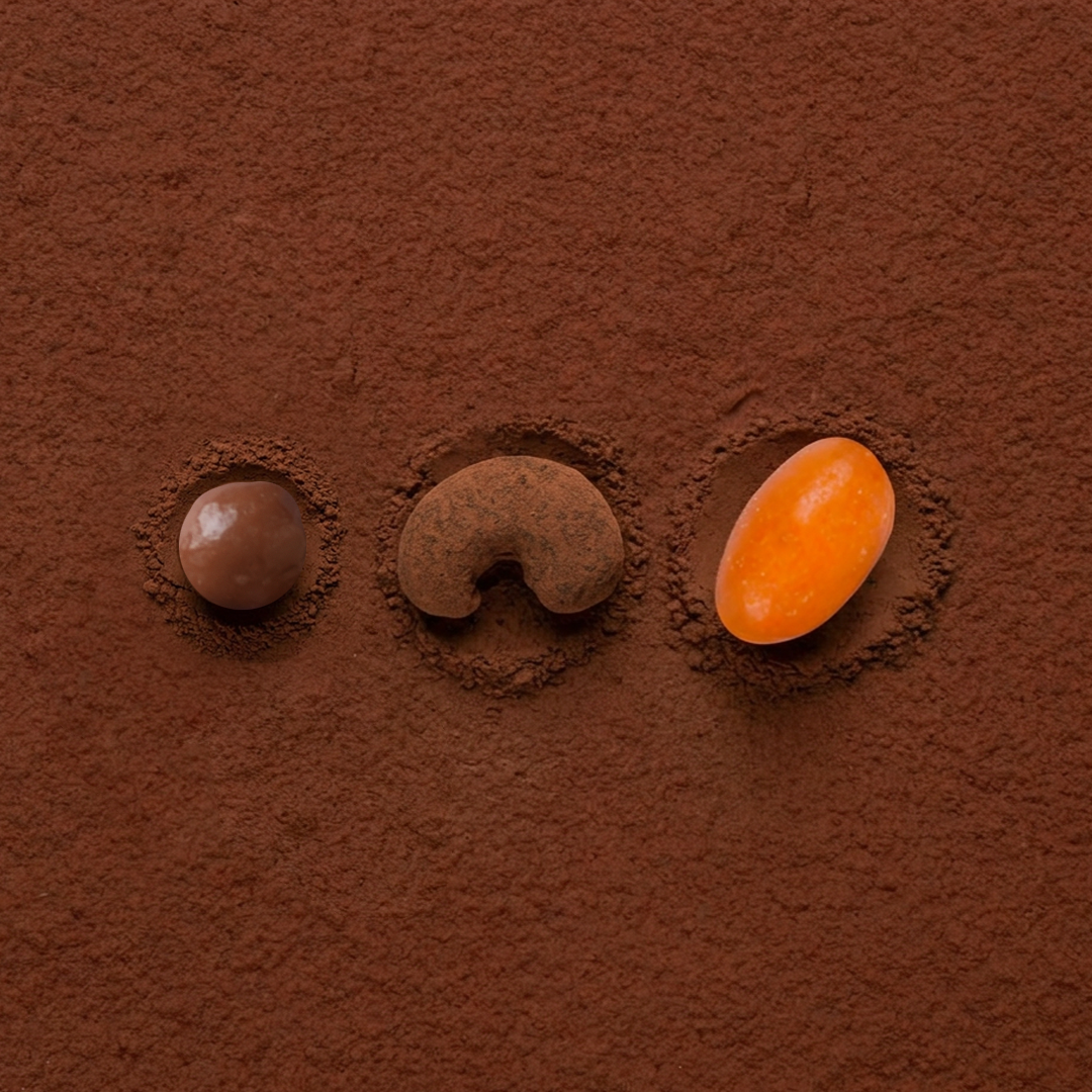 Cocoa-coated chocolate dragees, three assorted pieces: brown and orange